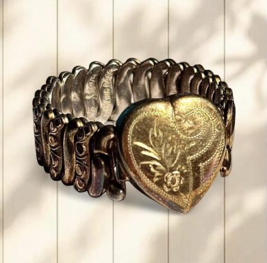 Gold toned sweetheart expansion bracelet. Heart has floral engraved details. Signed Co-Star on the inside