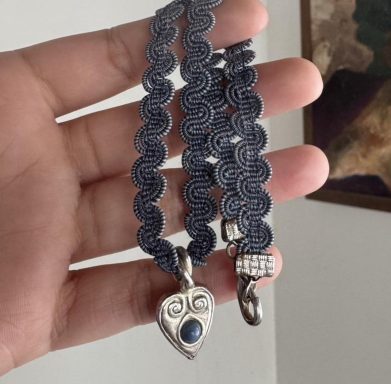 Blue swirly woven choker necklace featuring a silver toned heart pendant with a matching blue round cabochon