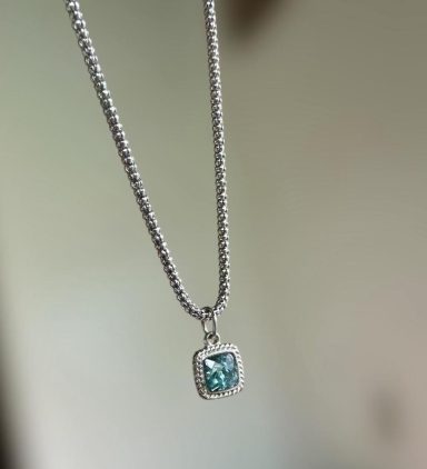 Silver toned square pendant with resin wavy blue cabochon on a silver toned chain