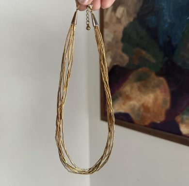 A multi-stranded gold toned necklace with straight beads imitating liquid gold